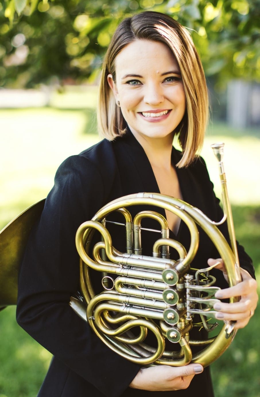 Photo of Renée Vogen holding a french horn